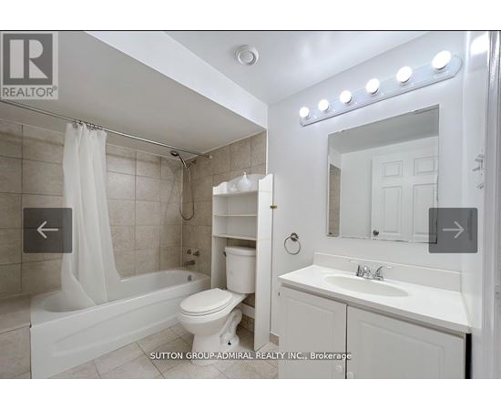 A white bathroom with a tub, toilet, and sink.