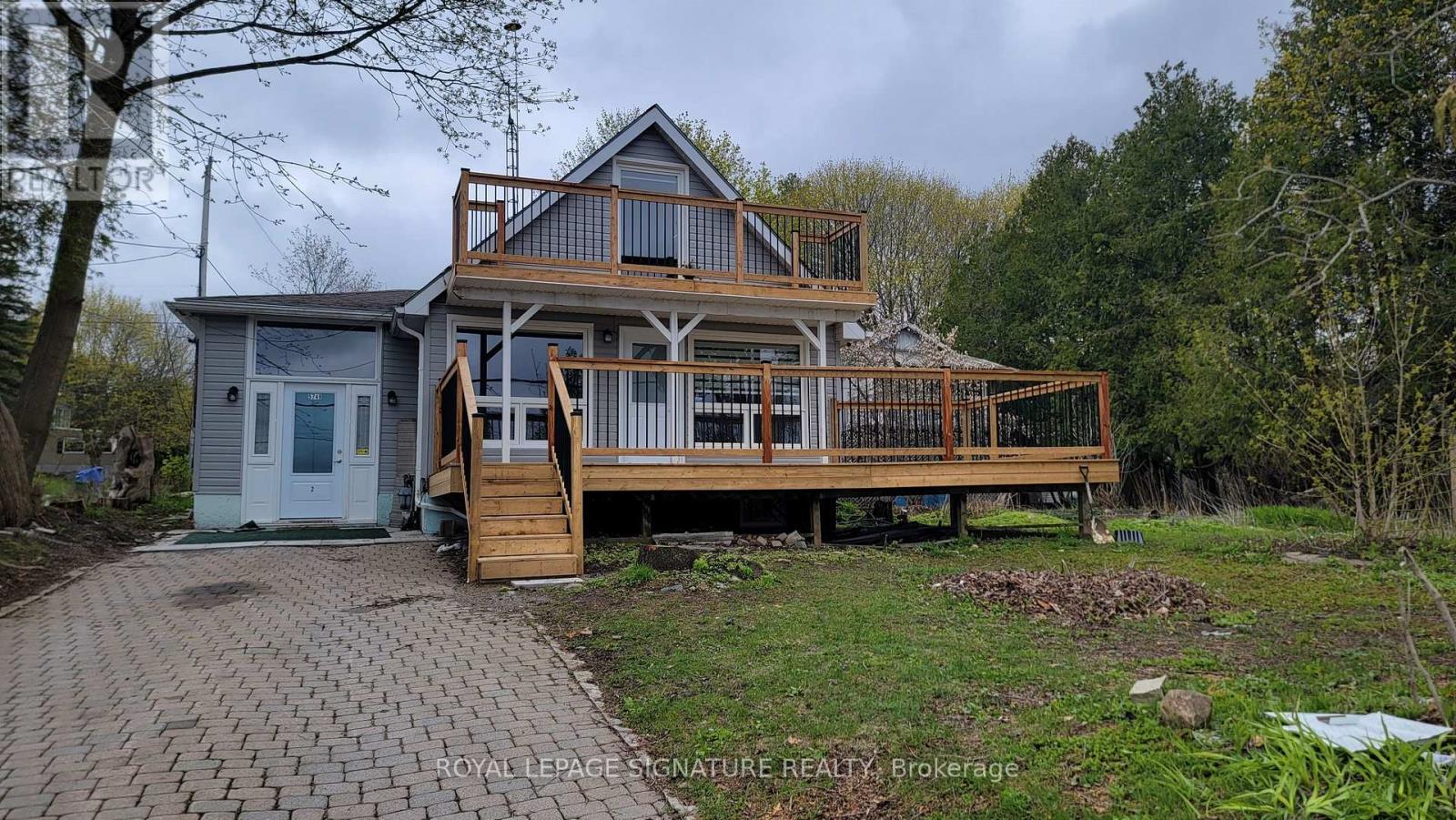 A house with a deck and a small entrance door.