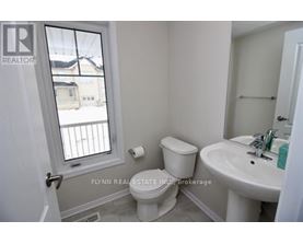 A white toilet sits next to a sink in a small bathroom.