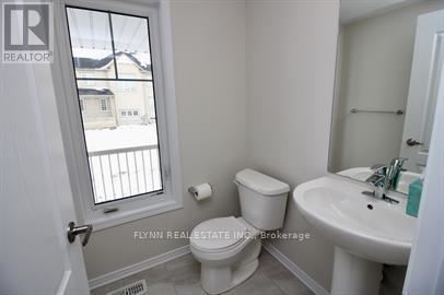 A white toilet sits next to a sink in a small bathroom.