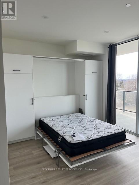 A bedroom with a bed on a platform and a sliding glass door.