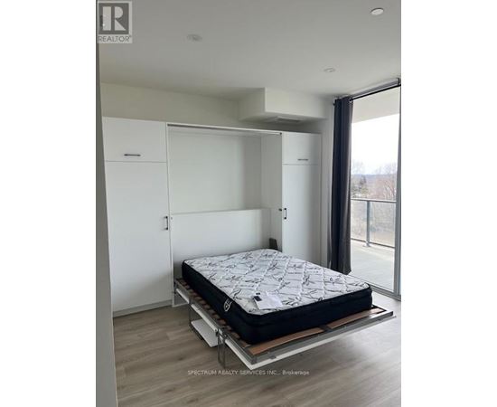 A bedroom with a bed on a platform and a sliding glass door.