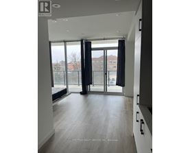 A spacious room with a view of the city through large windows.