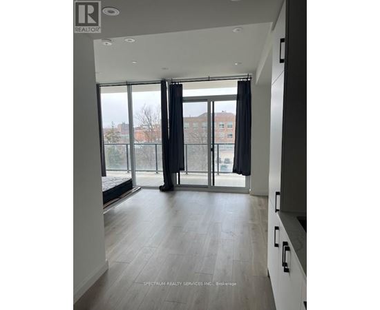 A spacious room with a view of the city through large windows.