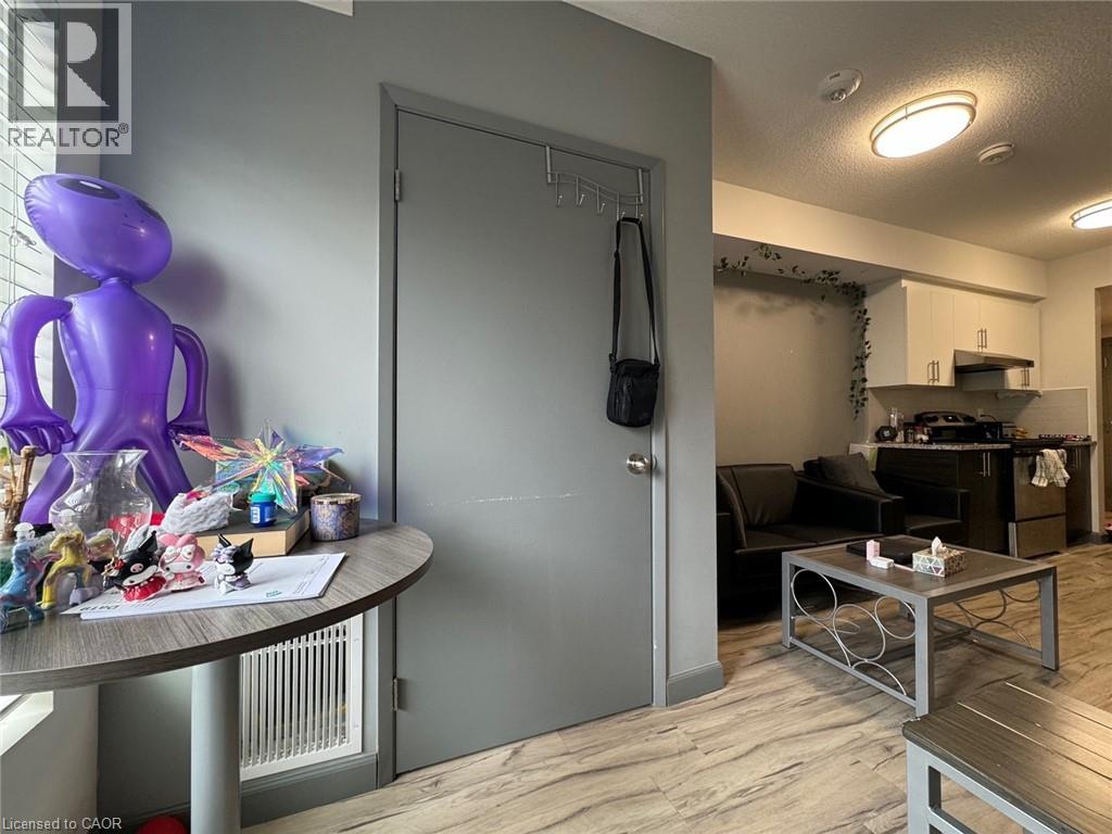 A living room with a grey door and a purple sculpture on the table.