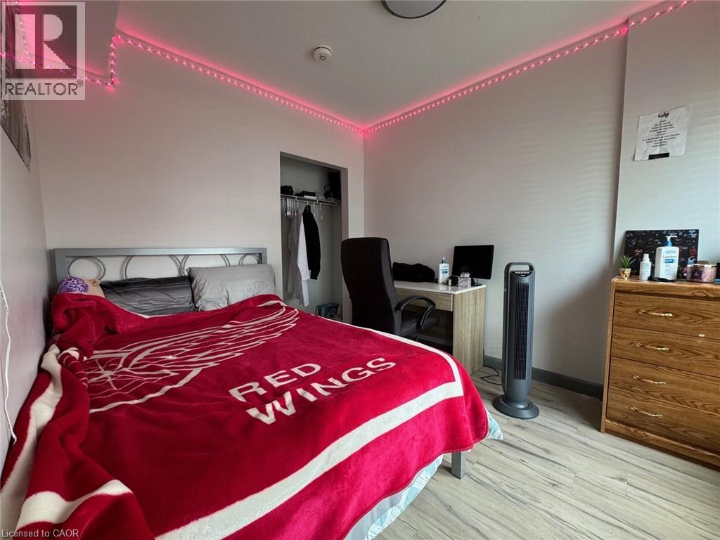 A bedroom with a bed covered in a Red Wings blanket.