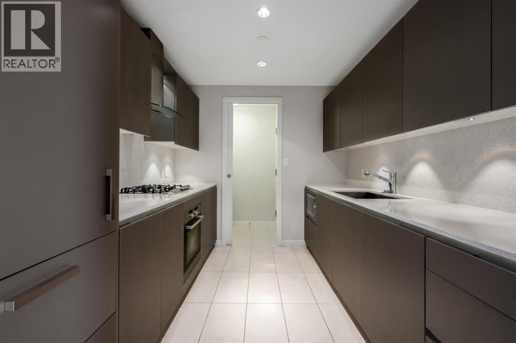 A modern kitchen with dark brown cabinets and white countertops.