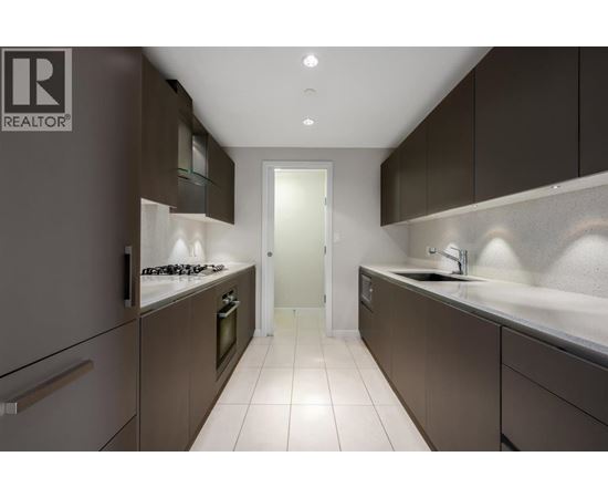 A modern kitchen with dark brown cabinets and white countertops.
