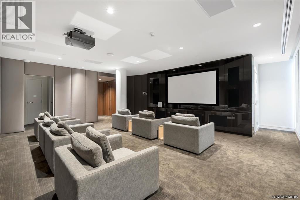 A modern living room with a large screen and comfortable seating.