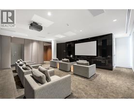 A modern living room with a large screen and comfortable seating.