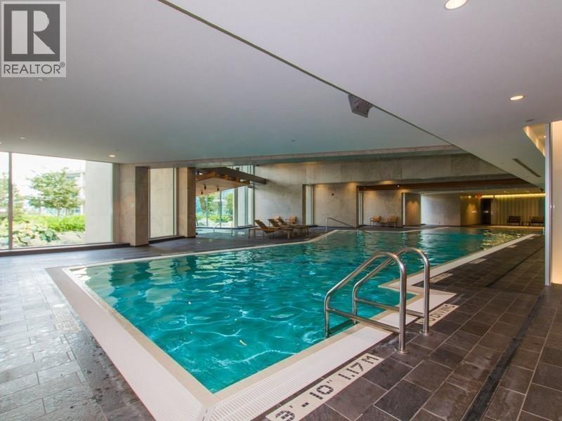 A swimming pool inside a building with a Realtor sign.