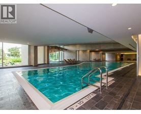 A swimming pool inside a building with a Realtor sign.