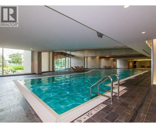 A swimming pool inside a building with a Realtor sign.