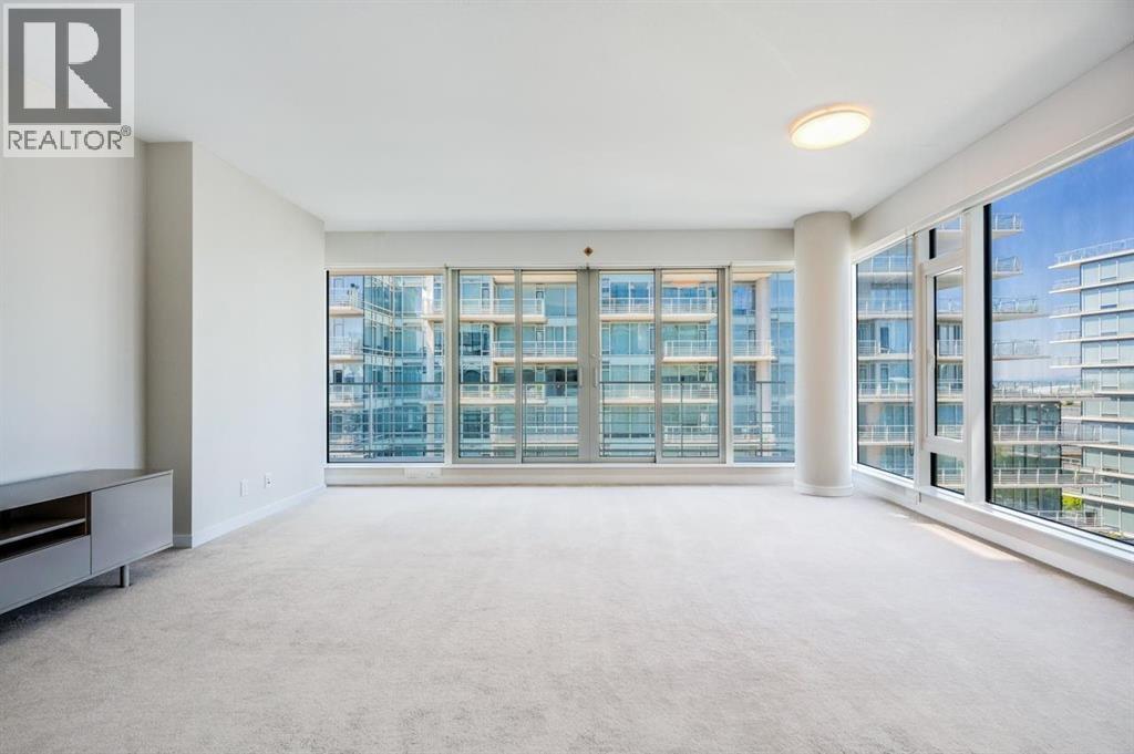 A spacious, well-lit room with large windows overlooking a cityscape.