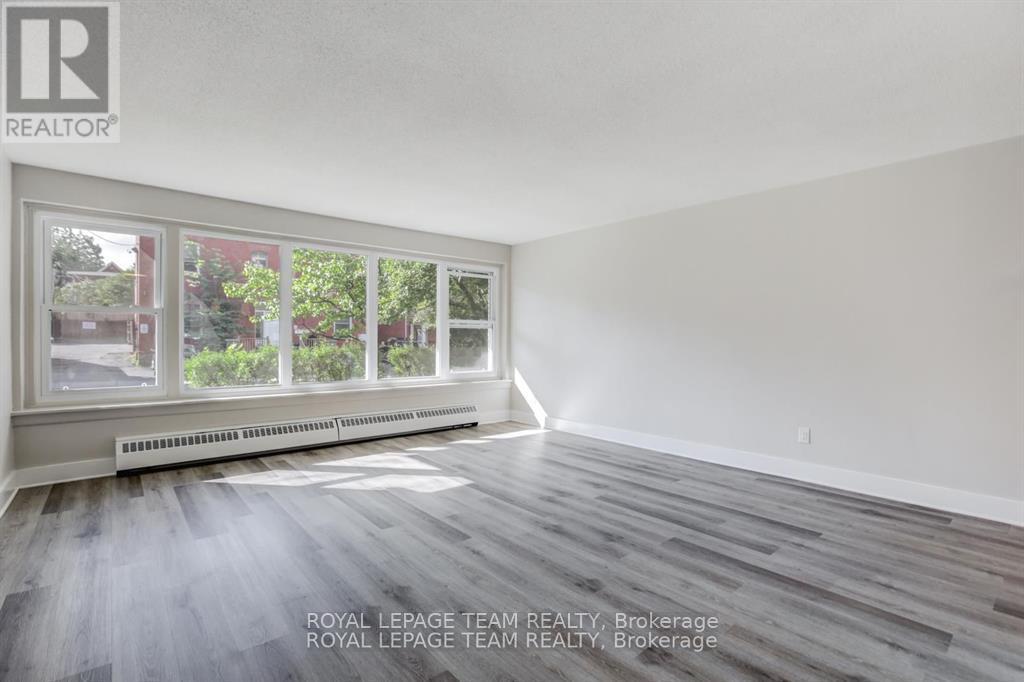 A room with a large window and wooden flooring.