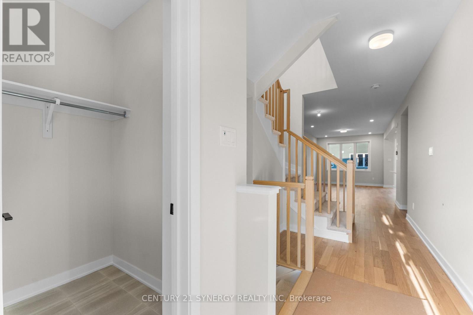 A hallway with a wooden staircase and white walls.