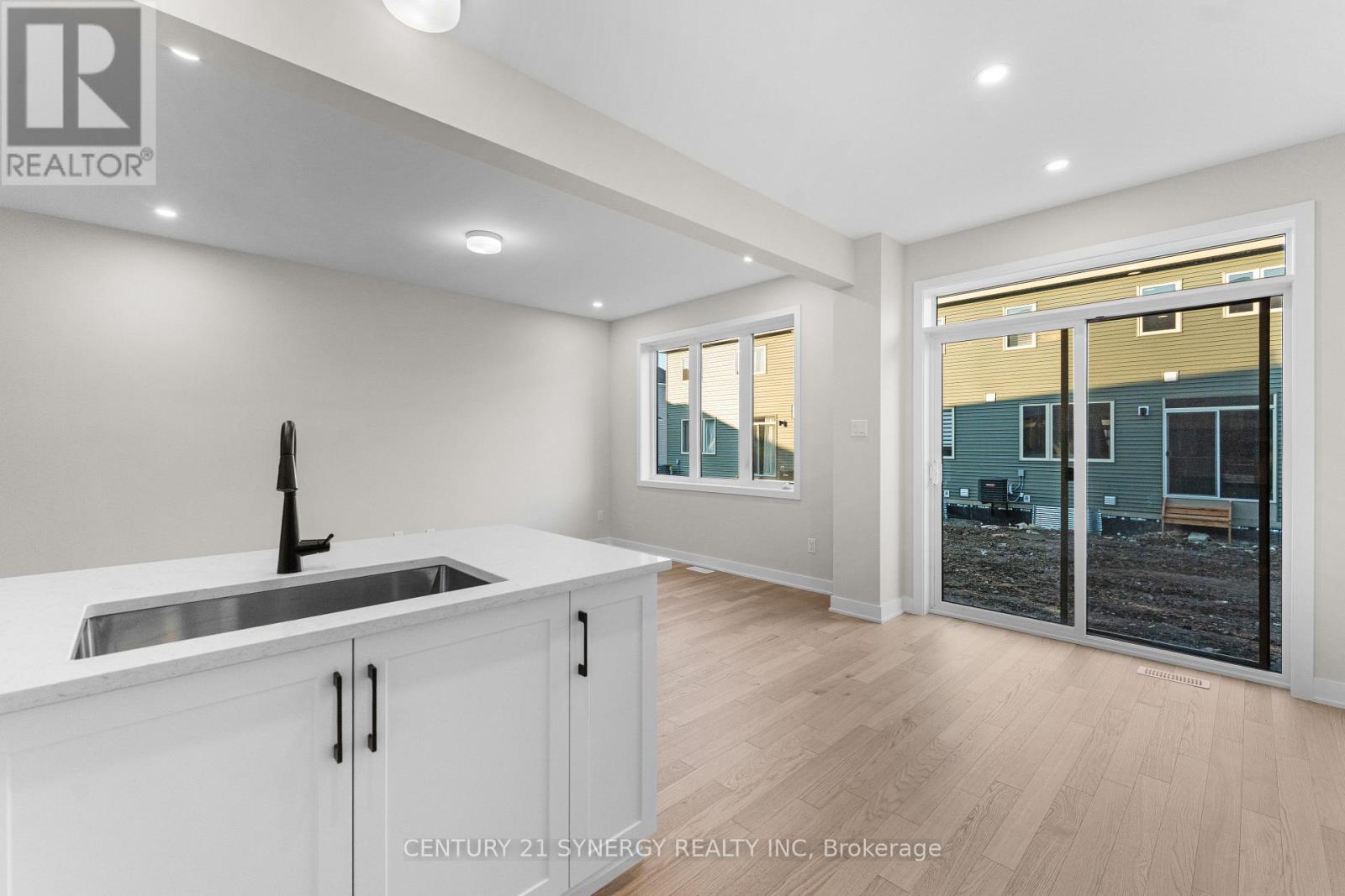 A modern kitchen with white cabinets and a stainless steel sink.