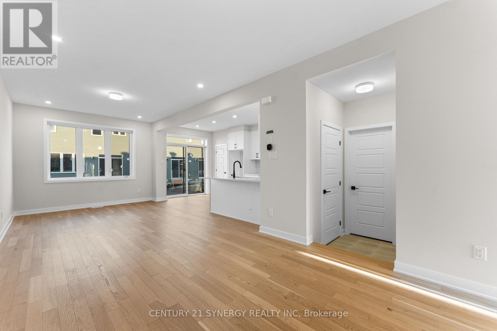 A spacious room with wooden floors and white walls.