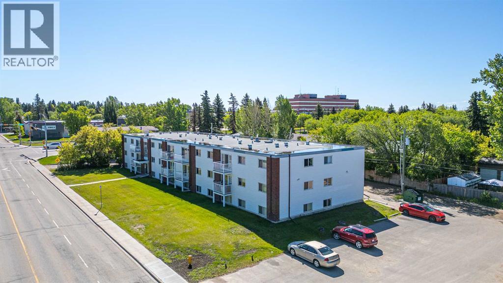 A large white building with a parking lot in front of it.