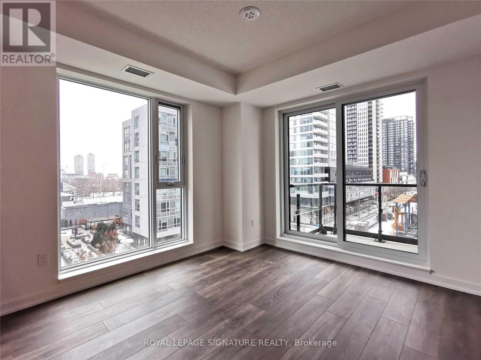 A room with a view of the city through large windows.