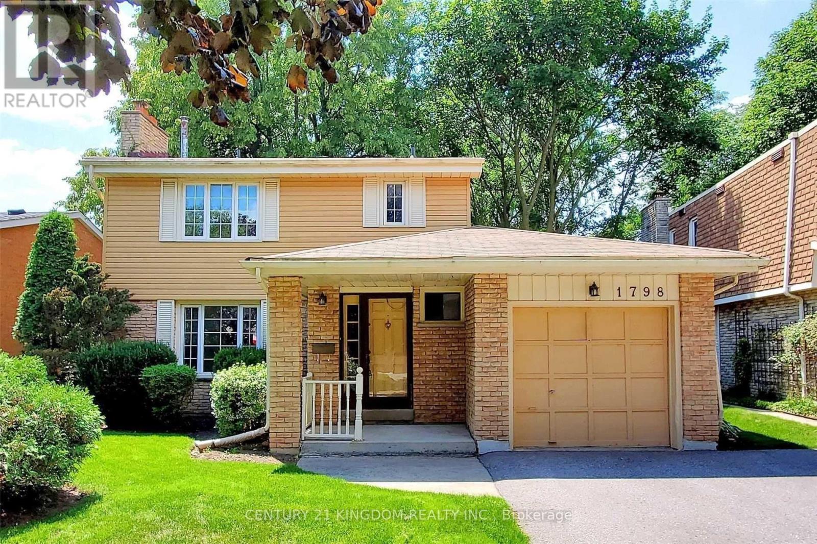A house with a garage and a driveway is for sale.