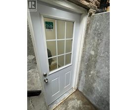 A white door with a glass panel and a sign on it.