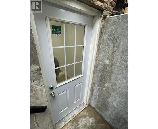 A white door with a glass panel and a sign on it.