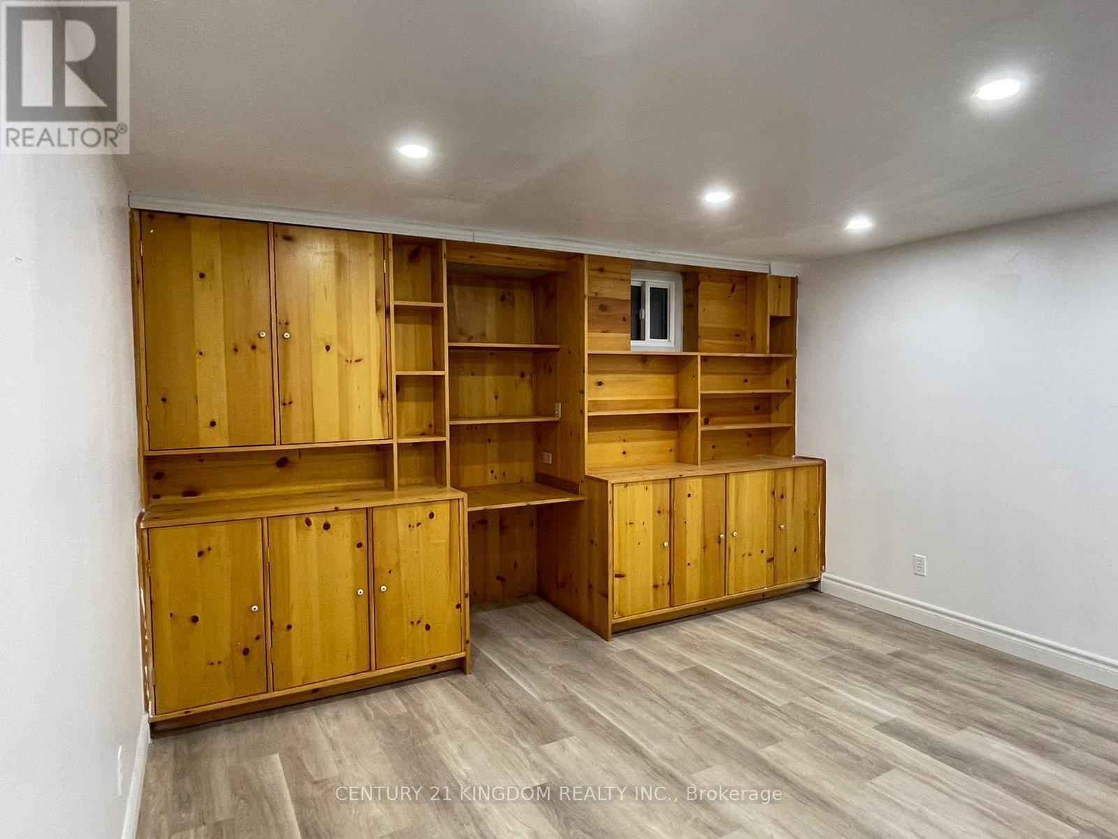 A room with wooden shelves and cabinets.