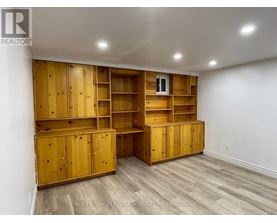 A room with wooden shelves and cabinets.