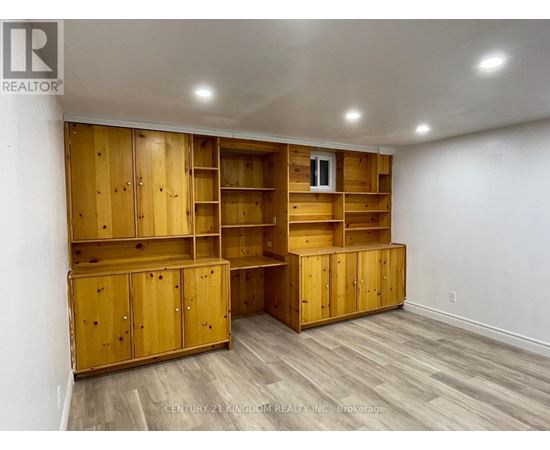 A room with wooden shelves and cabinets.