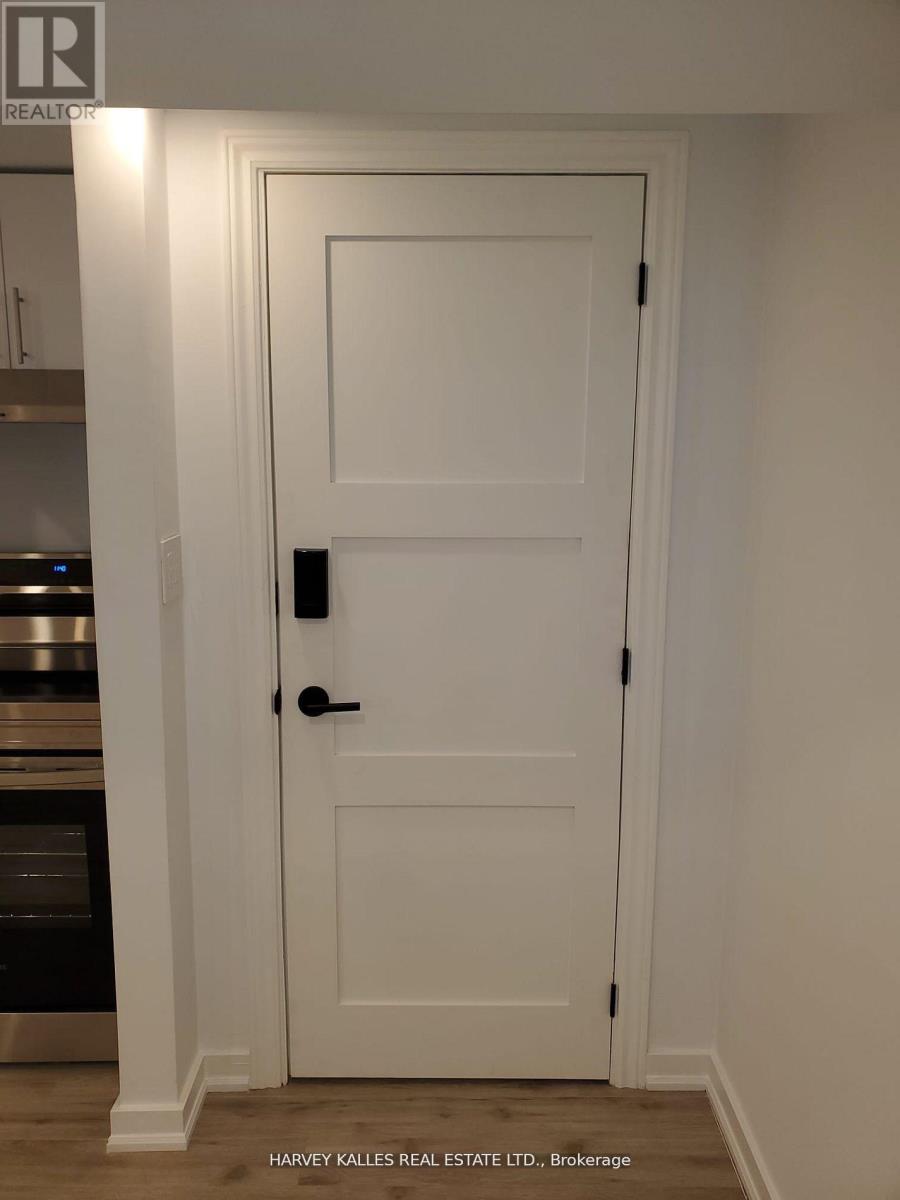 A white door with a black handle and lock in a room.