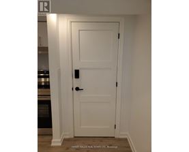 A white door with a black handle and lock in a room.
