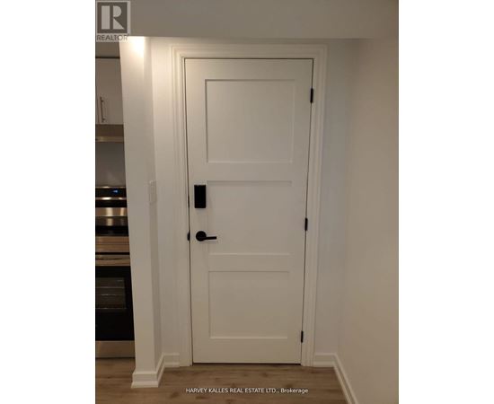 A white door with a black handle and lock in a room.