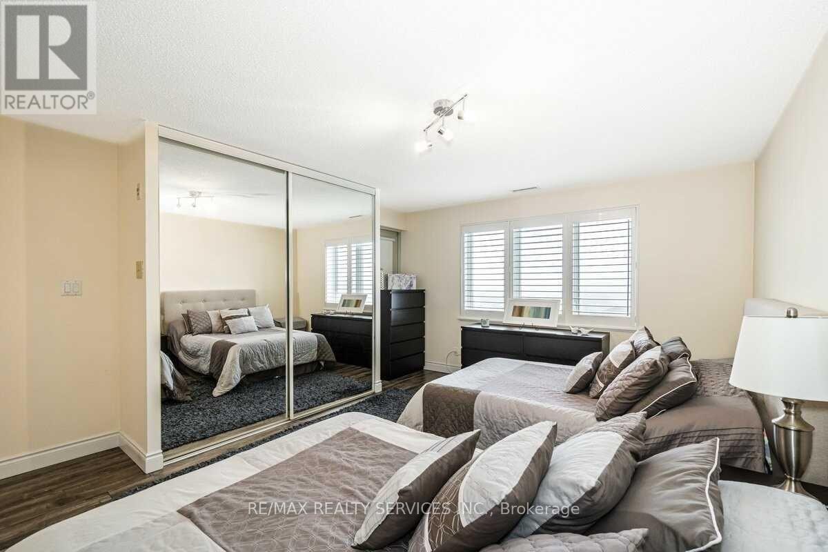 A bedroom with a large bed and a mirrored closet door.