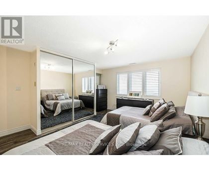 A bedroom with a large bed and a mirrored closet door.