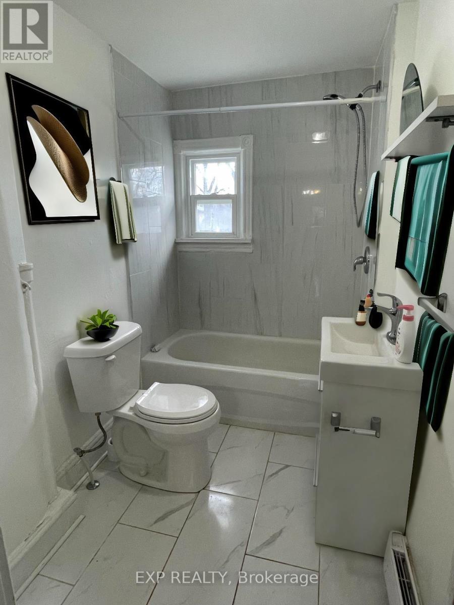 A bathroom with a toilet, sink, and bathtub.