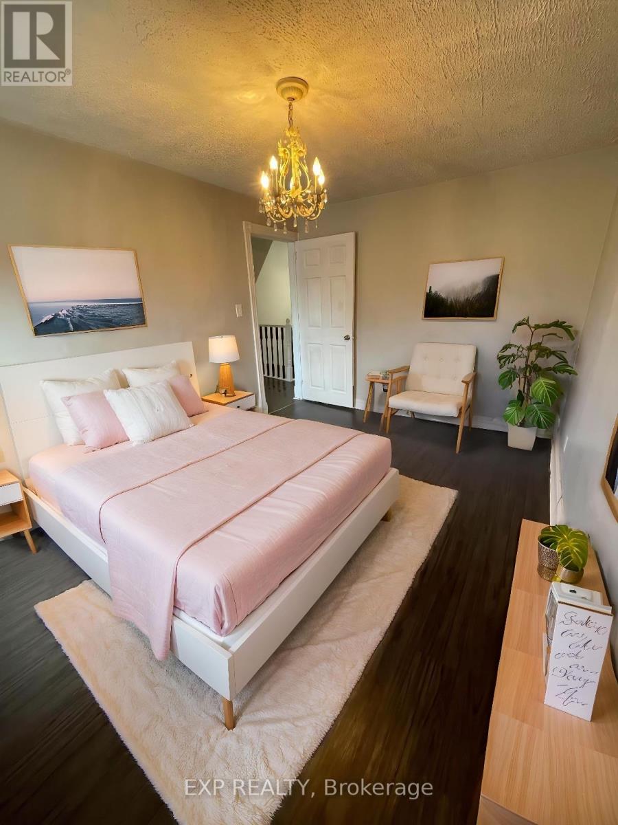 A bedroom with a large bed and a chandelier.