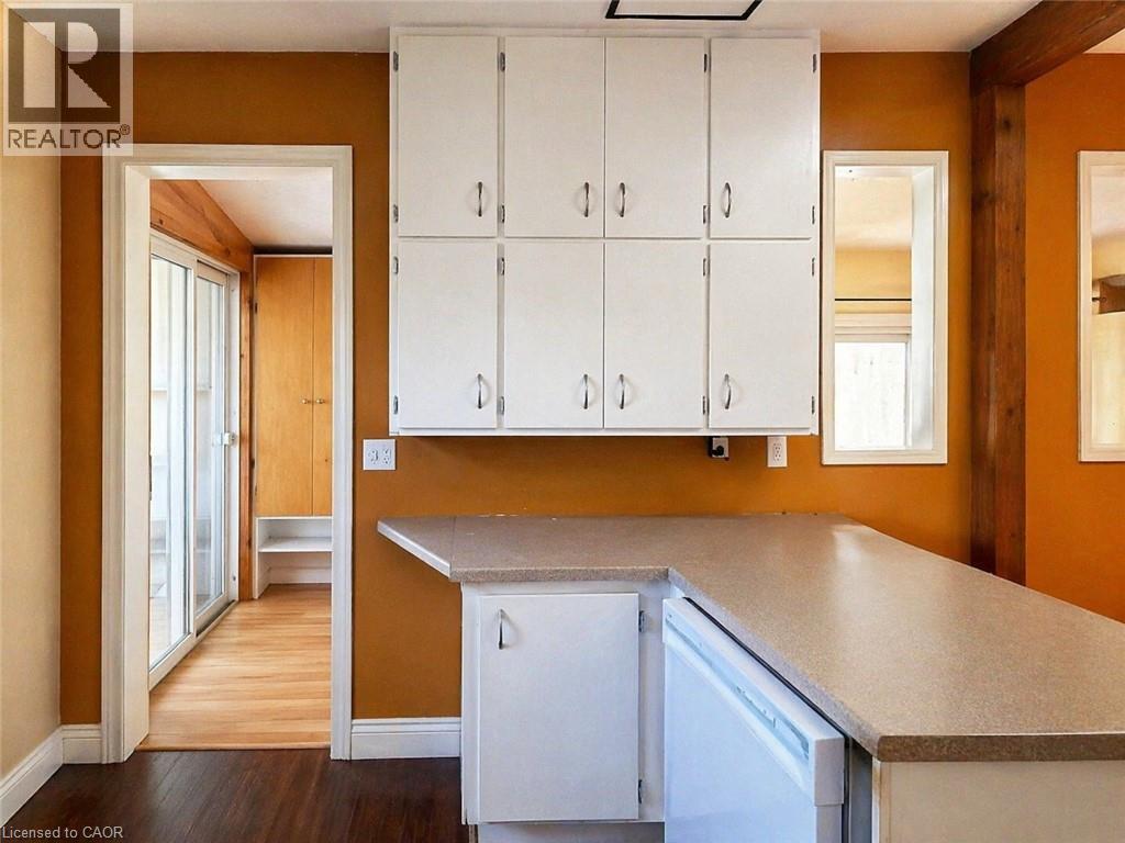 A kitchen with white cabinets and a white dishwasher.
