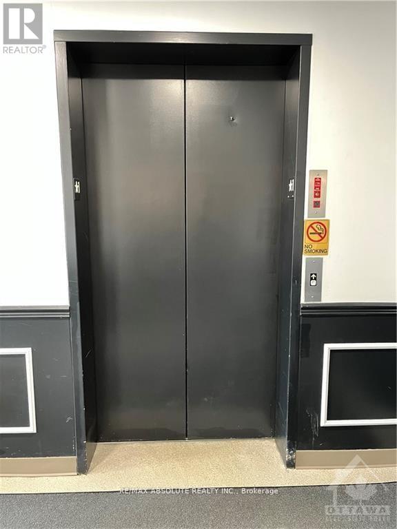 A black elevator with a sign on the wall that says "No Trespassing".