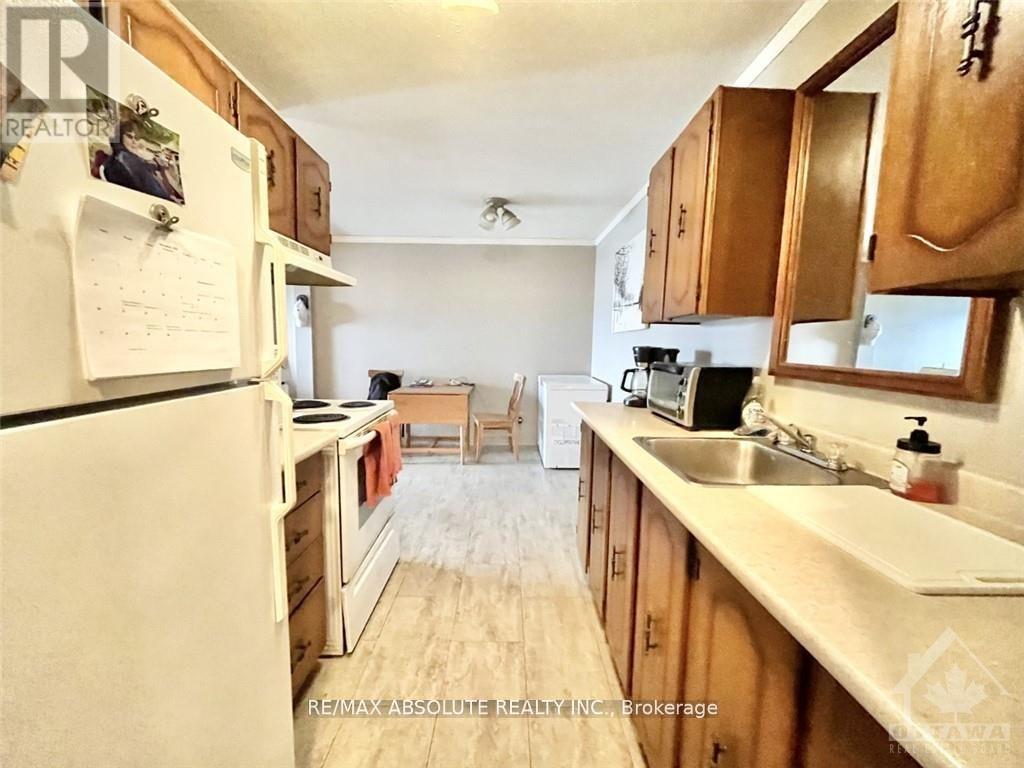 A kitchen with wooden cabinets and a white refrigerator.