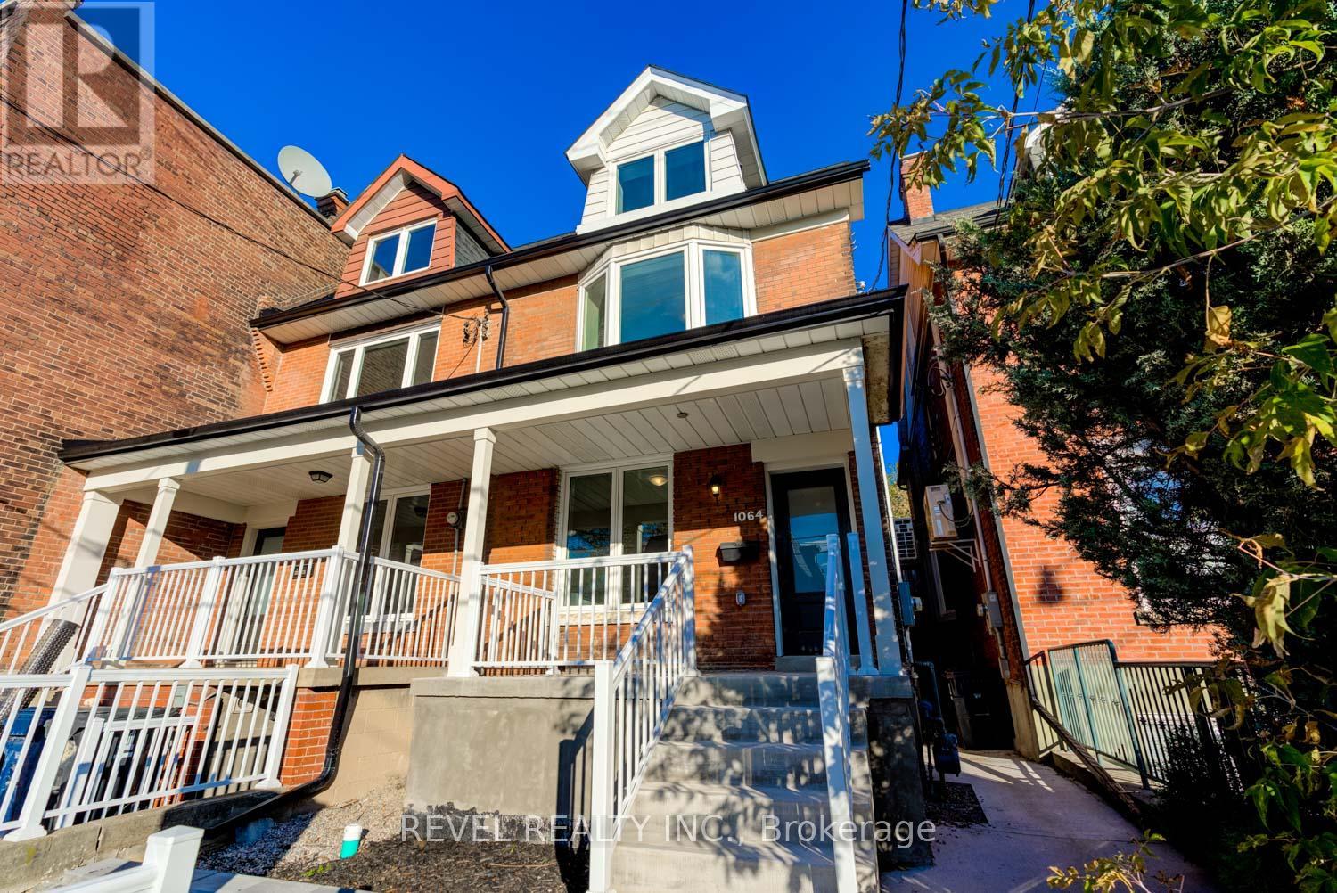 A house with a red brick exterior and a white porch.