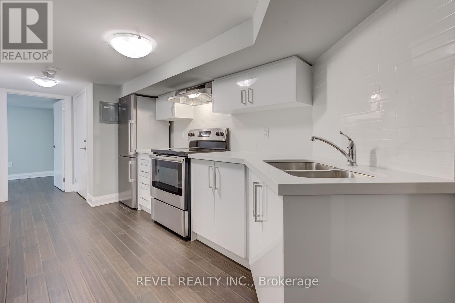 A modern kitchen with white cabinets and stainless steel appliances.