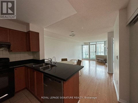 A kitchen with wooden cabinets and black countertops.