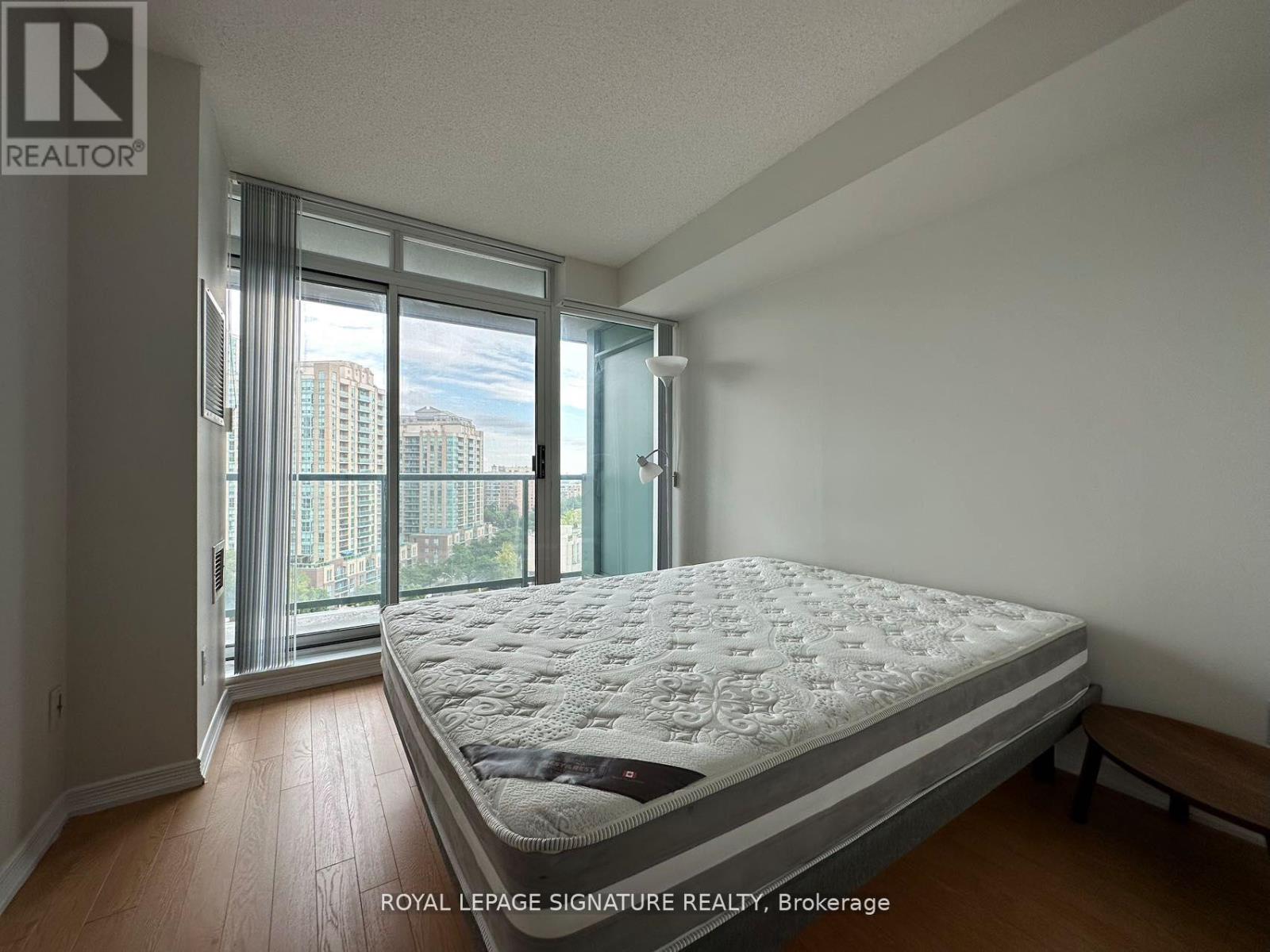 A bedroom with a large bed and a view of the city.