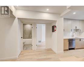 A modern kitchen with white cabinets and a wooden floor.