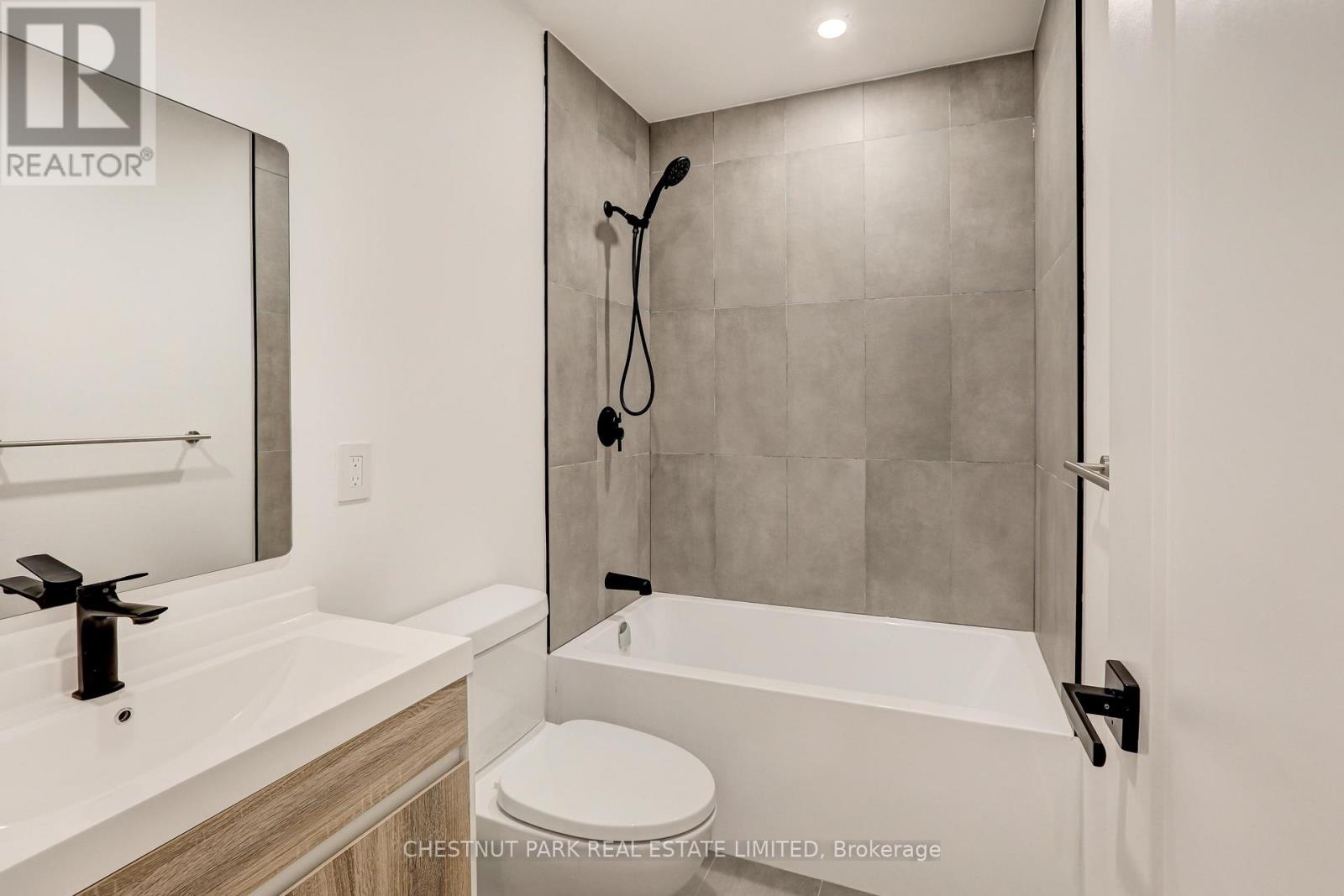 A modern bathroom with a white toilet and a walk-in shower.