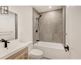 A modern bathroom with a white toilet and a walk-in shower.