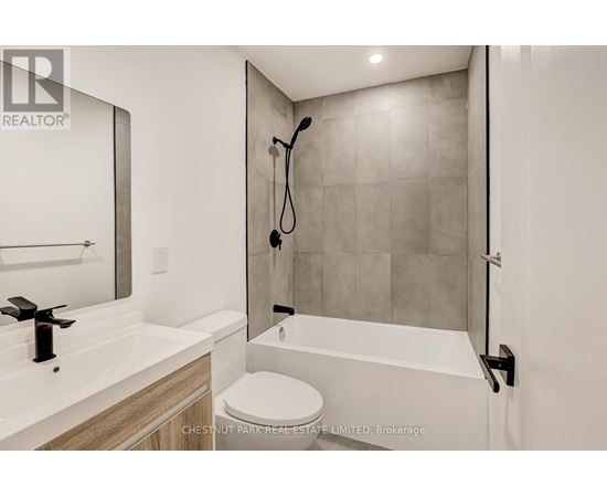 A modern bathroom with a white toilet and a walk-in shower.