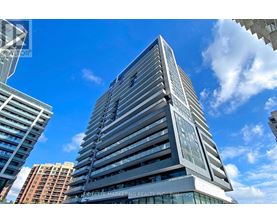 A tall building with a sign that reads "The Marketing Realty Inc." is seen against a blue sky.