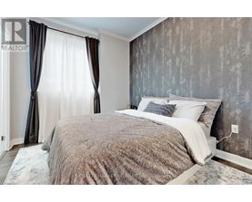 A bedroom with a large bed and a window with curtains.